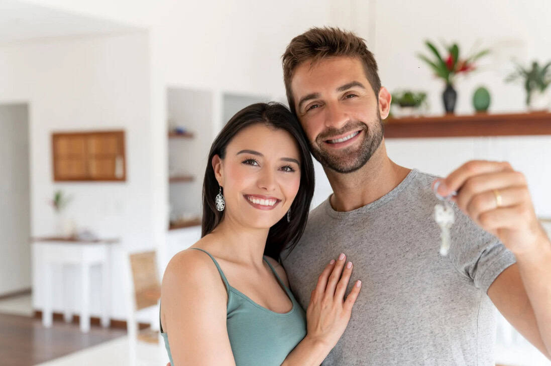 A photo of a couple holding their keys in their new home.